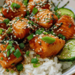 Viral salmon bites served over rice with cucumber and sesame seeds