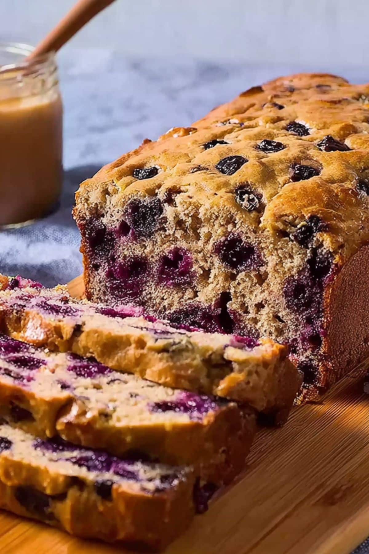 Vertical view of sliced blueberry cottage cheese bread with golden crust and juicy berries