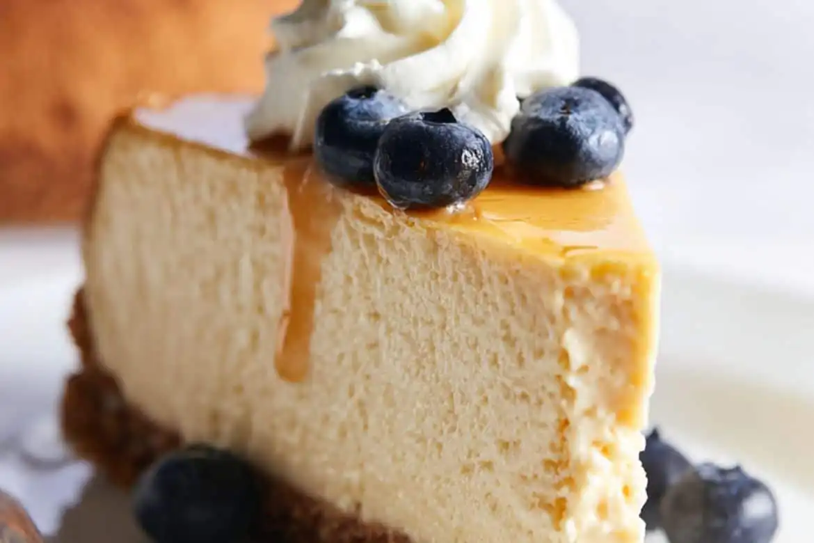 Slice of high protein cheesecake with blueberries and caramel