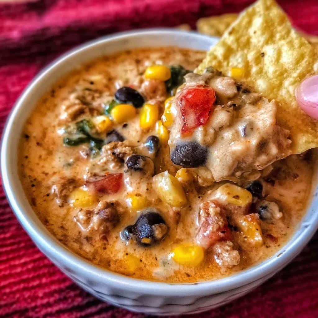 High protein creamy taco soup with beans, corn, and ground beef served with tortilla chips