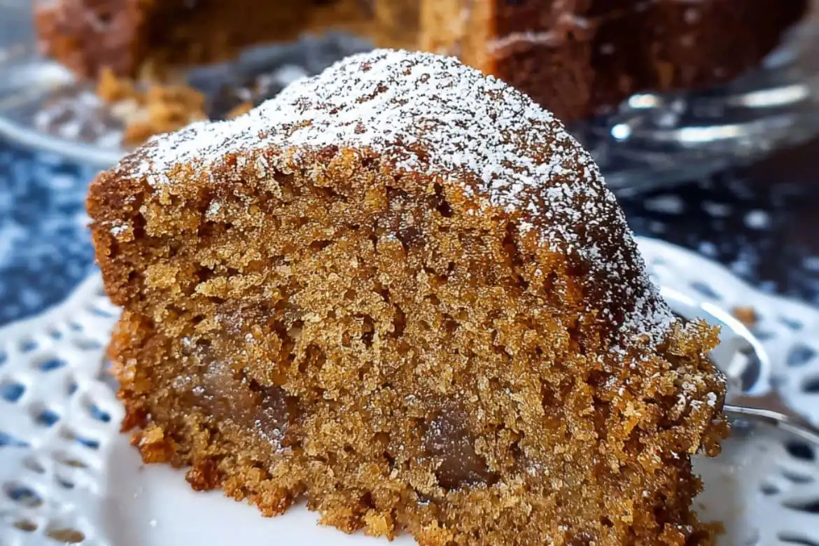 Moist slice of Amish applesauce cake dusted with powdered sugar