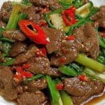 Beef stir-fry with celery and sliced red chilies coated in savory sauce
