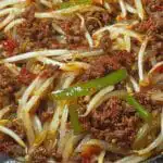 Ground beef and bean sprout stir-fry with bell peppers in skillet