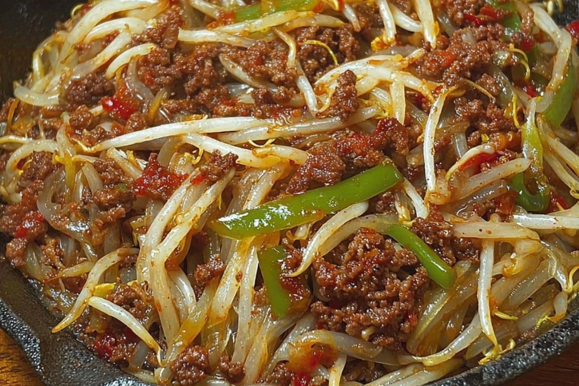 Ground beef and bean sprout stir-fry with bell peppers in skillet