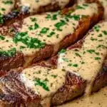 Juicy steak with creamy garlic sauce and chopped parsley