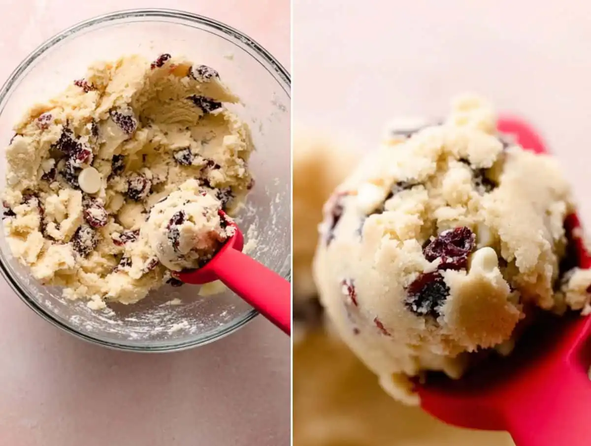 Cookie dough with cranberries and white chocolate chips in a glass bowl and scoop