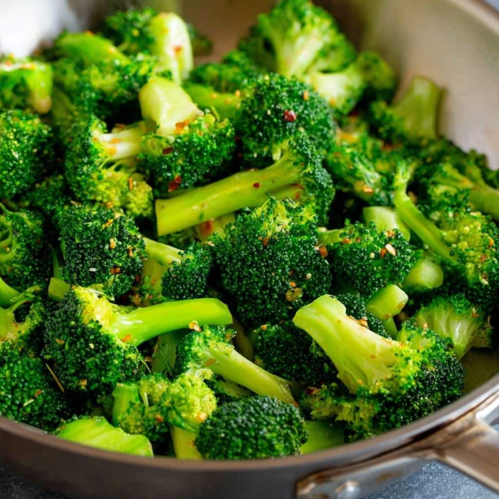 Bright green broccoli florets steaming in a pan for stir fry