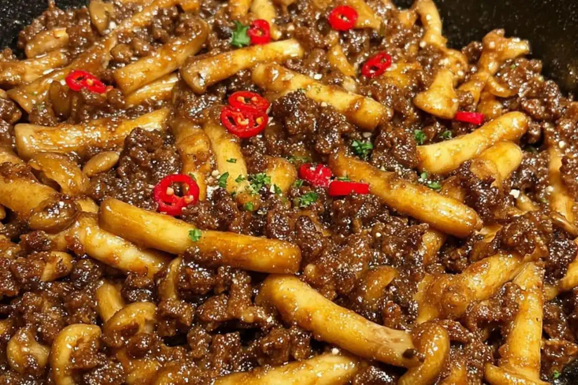 Close-up of stir-fried mushrooms with minced meat in savory sauce