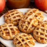 Mini apple pie cookies with lattice crust arranged on a white plate.