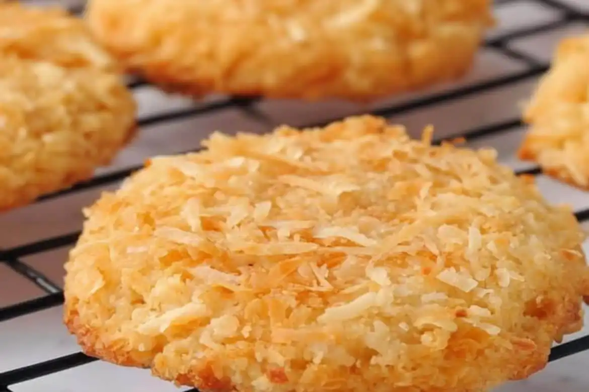 Close-up of golden brown coconut cookie on cooling rack