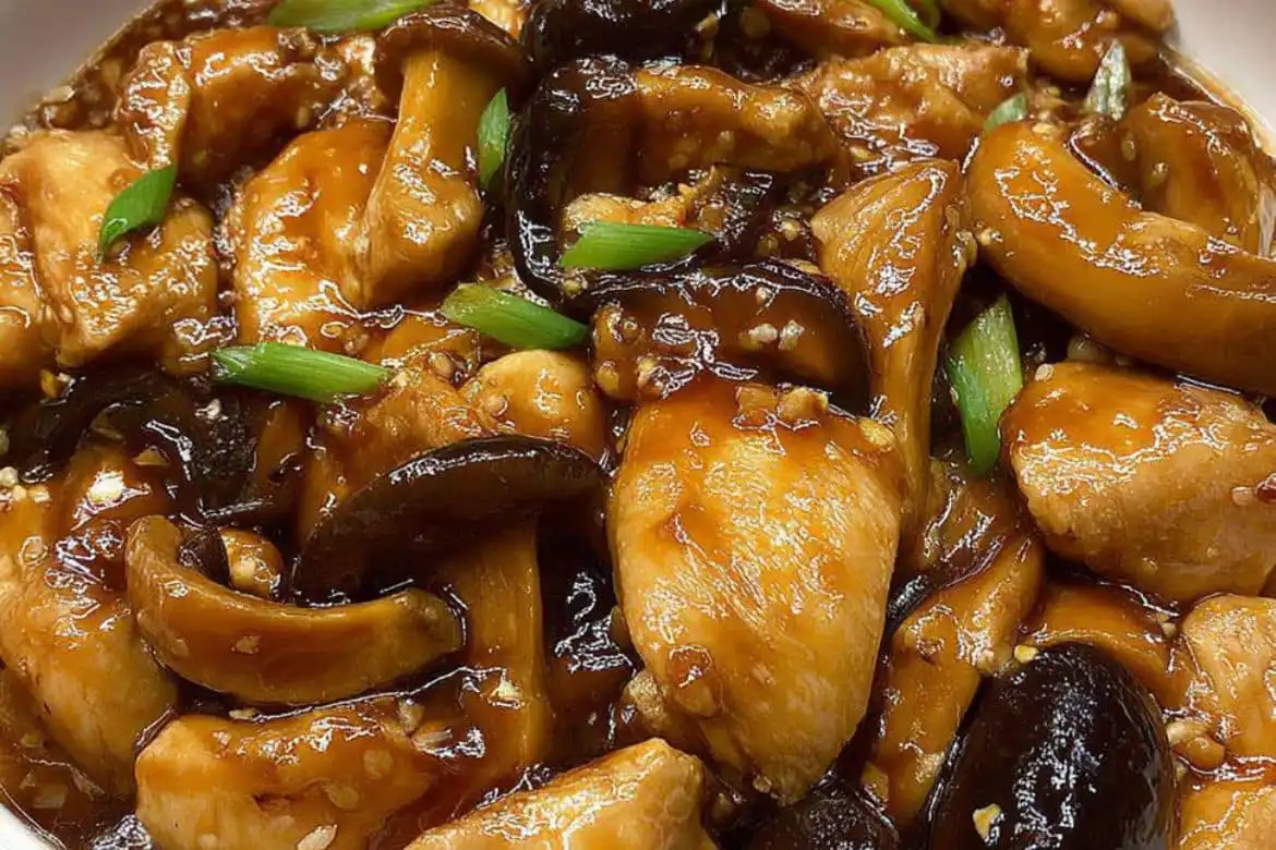 Close-up of steamed chicken with mushrooms in rich soy-based sauce