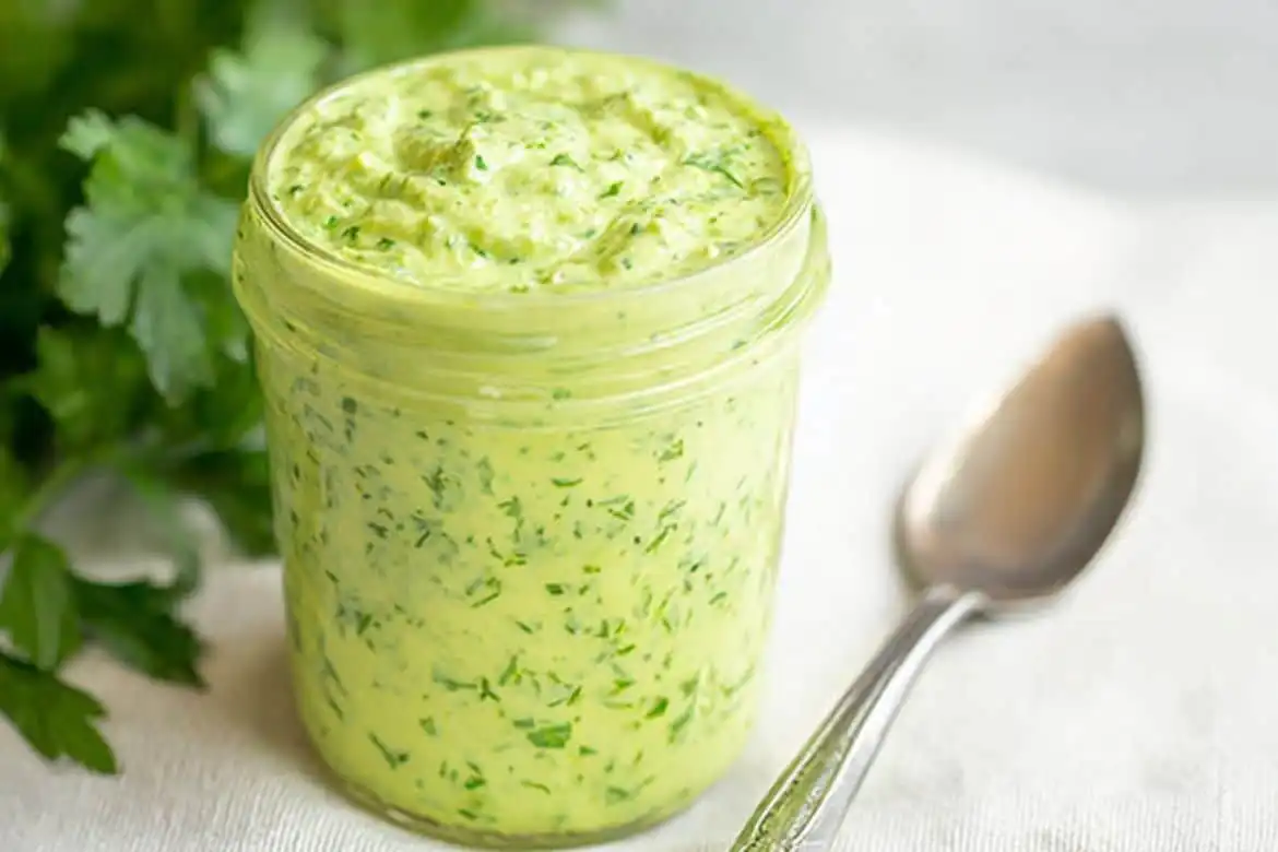 Green goddess dressing in a glass jar with herbs