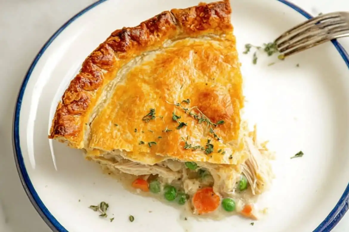 Slice of homemade chicken pot pie with golden crust and creamy filling