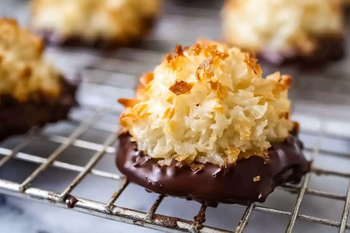 Chewy coconut macaroon dipped in dark chocolate on cooling rack