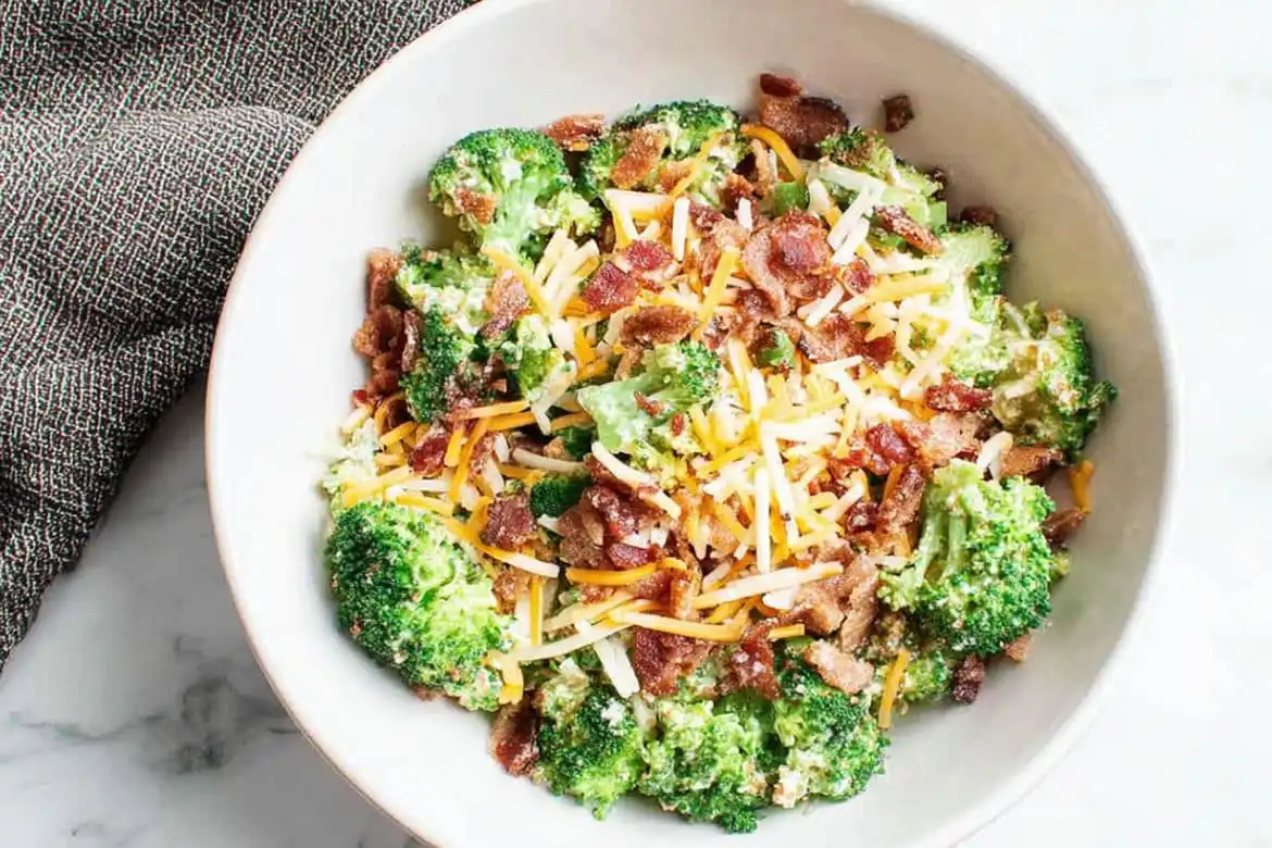Chicken Salad Chick broccoli salad with cheddar and bacon in a white bowl