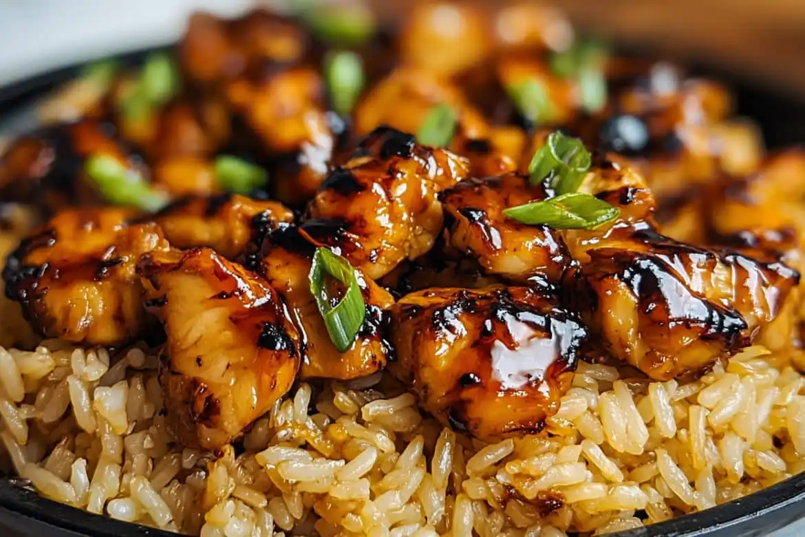 close-up of honey bbq chicken rice topped with green onions