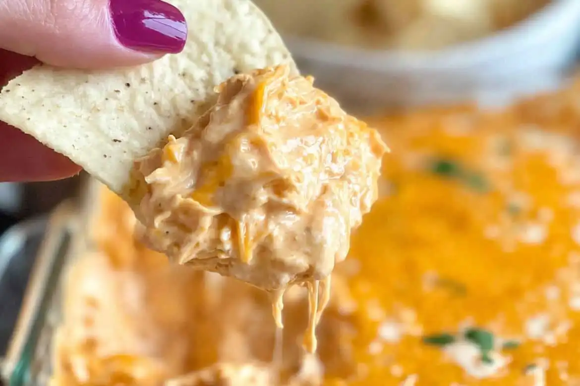 Close-up of buffalo chicken dip with canned chicken on a tortilla chip