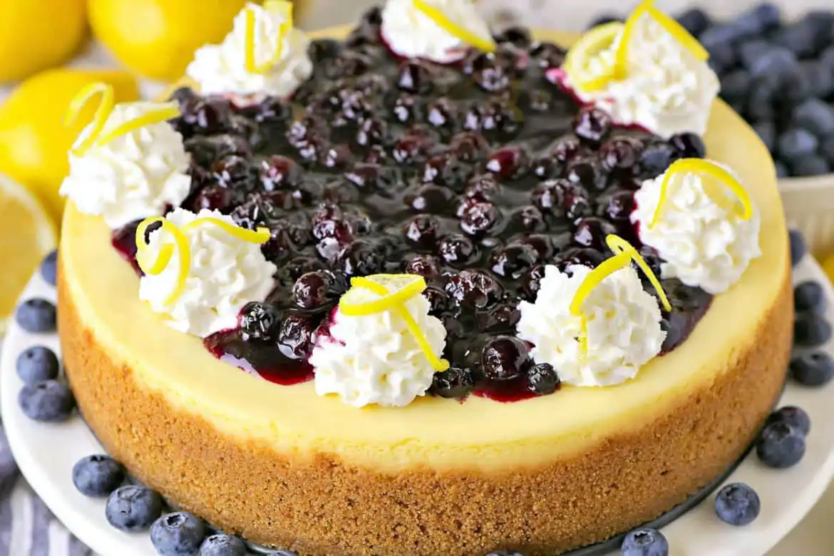 Lemon blueberry cheesecake topped with blueberry sauce and whipped cream