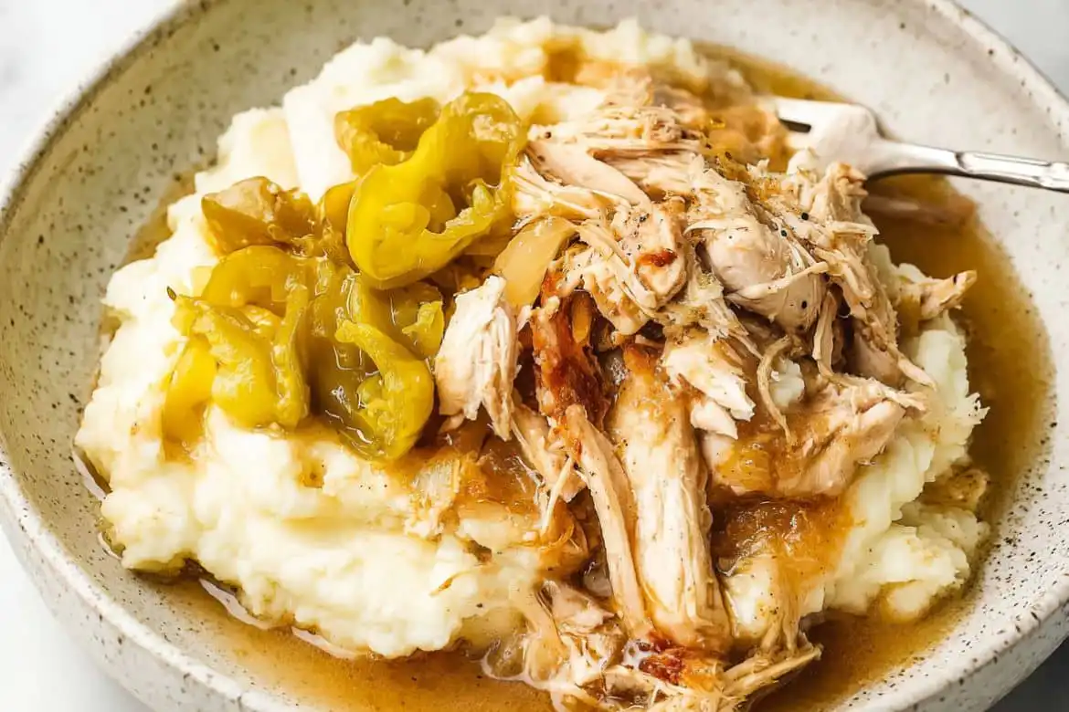 Mississippi chicken served over mashed potatoes with pepperoncini and gravy