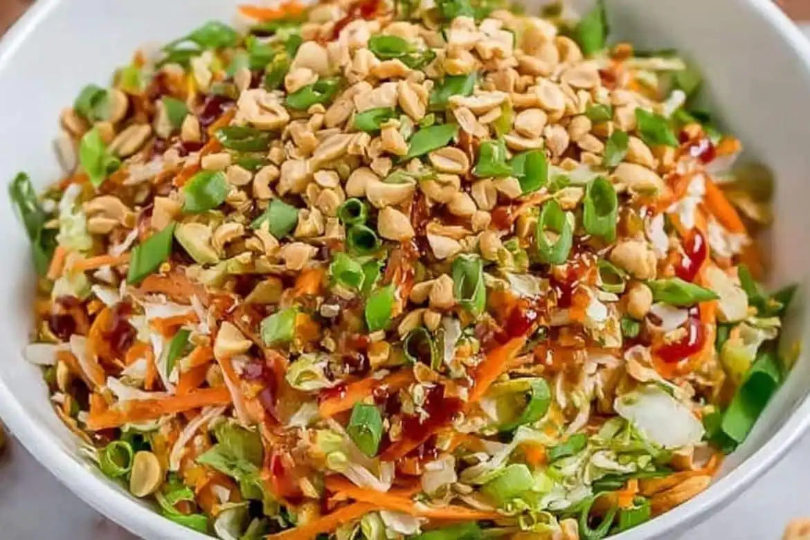 Thai peanut salad topped with green onions, chopped peanuts, and sweet chili dressing
