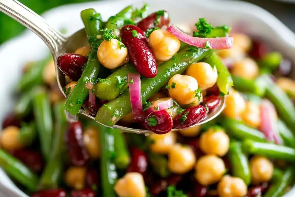 Three bean salad with kidney beans, garbanzo beans, and green beans in tangy dressing